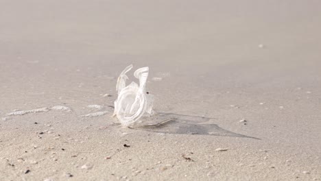 Plastikmüll-Am-Sandstrand-Mit-Auflaufenden-Wellen,-Konzept-Der-Umweltverschmutzung