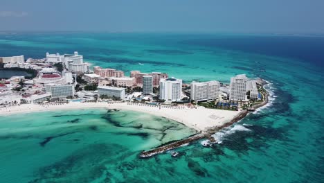 Aerial-drone-view-of-Cancun-hotels-and-resorts-overlooking-turquoise-ocean-water,-Mexico