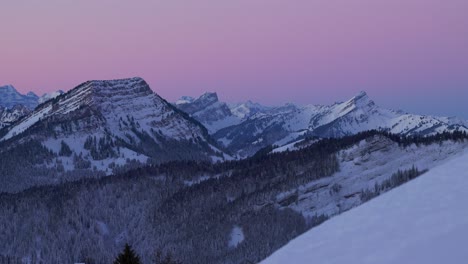 Experience-the-beauty-of-sunrise-over-a-snow-covered-mountain-range-silhouette-through-this-captivating-drone-footage