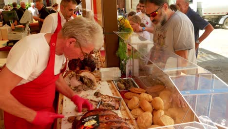 Ein-Metzger-Schneidet-Schweinefleisch-Für-Touristen-Beim-Spanferkelfest-Von-Monte-San-Savino