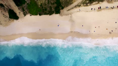 Myrtos-beach-with-turquoise-waves-and-sandy-shore,-kefalonia,-greece,-sunny-day,-aerial-view