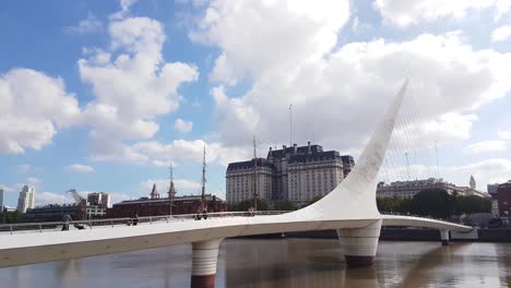 Timelapse-of-Sky-and-People-Passing-Ponte-de-la-Mujer,-Buenos-Aires,-Argentina,-Swing-Bridge-is-Modern-Architectural-Landmark-in-Puerto-Madero