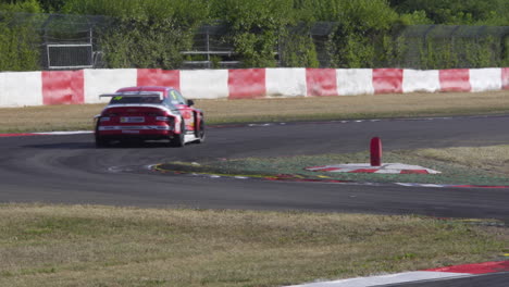 Coche-De-Carreras-Pasando-Por-Encima-De-Bordillos-A-Través-De-Chicane-A-Alta-Velocidad,-Tiro-De-Seguimiento