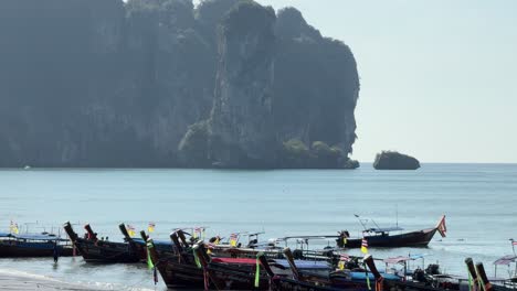 Thailand-long-tail-boats-docked-at-ocean-beach-near-steep-limestone-Krabi
