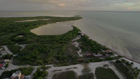 Backwards-Revealing-Aerial-of-Small-Seaside-Village-on-Coastal-Island