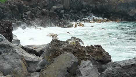 Fuertes-Salpicaduras-De-Agua-Hacia-Las-Rocas-En-La-Orilla-Del-Mar,-Cámara-Lenta-Estática-De-Cierre