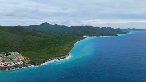 Exuberantes-Montañas-Verdes-Inclinadas-Hasta-La-Costa-De-La-Isla-Caribeña-De-Westpunt-Curacao,-Antena-Panorámica