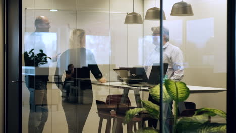 Colegas-En-La-Sala-De-Reuniones-De-Pie-En-Lugar-De-Sentados,-Ambiente-De-Trabajo-Saludable