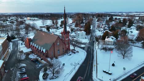 Historische-Kirche,-Fahrende-Autos-Und-Wehende-Amerikanische-Flagge-Im-Winterschnee