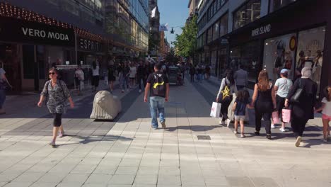 People-walk-on-Drottninggatan-in-Stockholm,-Sweden