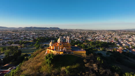 Drohne-Umkreist-Die-Kirche-Unserer-Lieben-Frau-Von-Den-Heilmitteln-Im-Sonnigen-Cholula,-Mexiko
