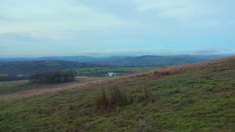 Dusk-over-Lyme-Park-with-sweeping-views-of-green-landscape-and-distant-hills,-overcast-sky