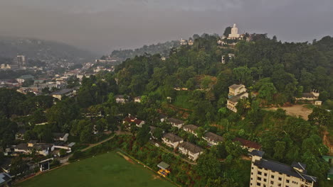 Kandy-Sri-Lanka-Aerial-v29-drone-flyover-cricket-ground-and-hillside-Buddhist-temple-capturing-views-of-beautiful-sunrise-cityscape-with-dense-misty-clouds---Shot-with-Mavic-3-Cine---April-2023