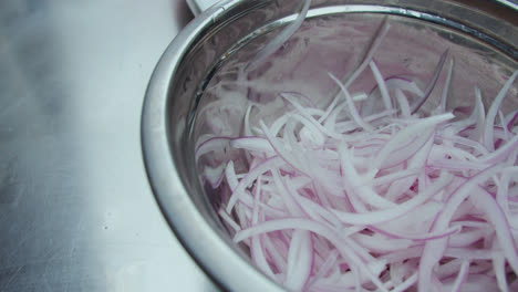 Beautiful-closeup-detail-of-a-plate-with-onion-cut-into-strips-and-washed-to-be-served-in-sarsa