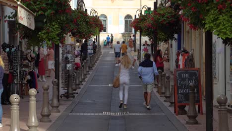 Couple-walks-on-beautiful-shopping-street-in-Antibes-Old-Town,-France