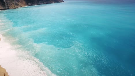 Playa-De-Myrtos-Con-Vibrantes-Aguas-Color-Turquesa-Y-Vibraciones-Costeras,-Cefalonia,-Grecia,-Luz-Natural,-Vista-Aérea