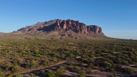 Wüstenstraße-Mit-Kakteen,-Die-Bei-Sonnenuntergang-Zu-Den-Superstition-Mountains-In-Arizona-Führt