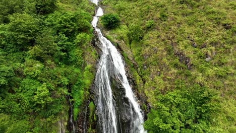 Lush-greenery-surrounds-Efrata-Waterfall-cascading-near-Lake-Toba,-aerial-view