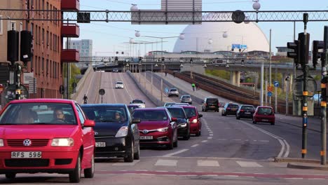 Car-traffic-and-subway-train-in-Stockholm,-Globe-Arena-in-background