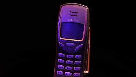 Vintage-Nokia-3210-Keypad-Mobile-Phone-on-Spinning-Display-with-Black-Background-Close-Up