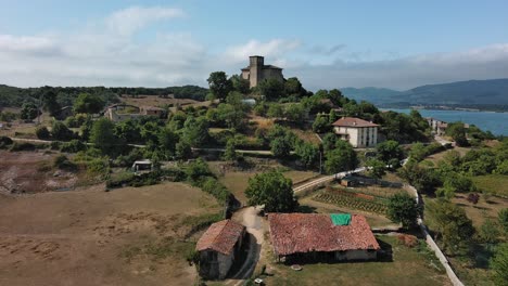 Pueblo-De-Nanclares-De-Gamboa-Con-Castillo-En-Medio-De-Vegetación,-País-Vasco,-España,-Vista-Aérea