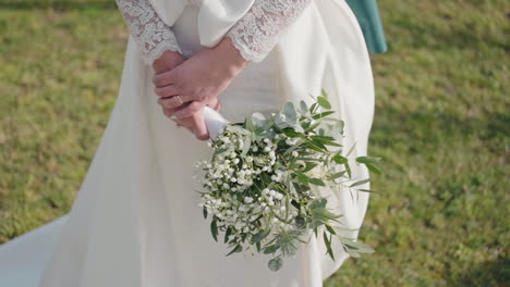 Braut-Mit-Blumenstrauß-Und-Spitzenärmeldetail