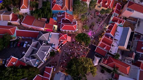 Panoramic-aerial-top-down-bird's-eye-view-of-Kura-Hulanda-village-in-Otrobanda-Willemstad-Curacao-at-dusk,-vibrant-multicolored-roofs