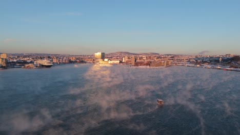 Golden-Hour-View-Over-Bjorvika-In-Sentrum-borough-of-Oslo,-Norway-With-Fog-Floating-Over-Water