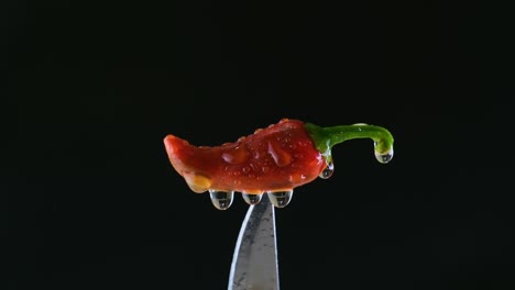 Wassernebel-Auf-Rotem-Chili-Auf-Einem-Messer-Mit-Schwarzem-Hintergrund