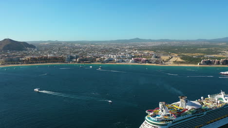 Drone-shot-over-a-cruiseliner-and-boats-on-the-coast-of-Cabo-San-Lucas,-Mexico