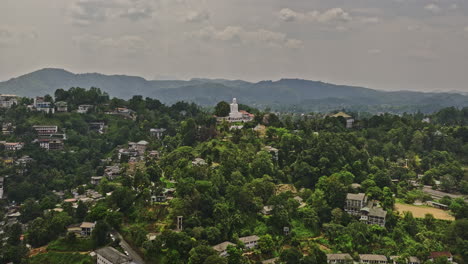 Kandy-Sri-Lanka-Aerial-v15-flyover-hilltop-Bahirawakanda-Buddhist-temple,-fly-around-white-Buddha-sculpture-capturing-views-of-cityscape-and-mountainous-landscape---Shot-with-Mavic-3-Cine---April-2023