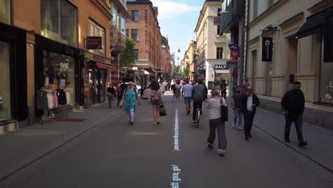 Pedestrians-and-bicyclists-move-around-in-central-Stockholm,-Sweden,-on-a-summer-day