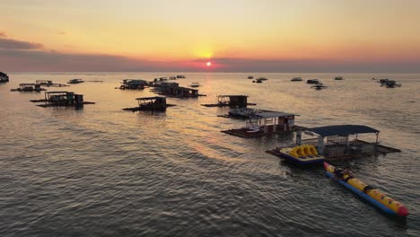 Silhouette-Von-Menschen-Im-Wasser-Und-Parkenden-Holzbooten-Am-Strand-Auf-Den-Philippinen