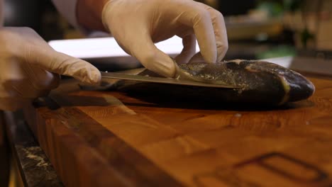 Chef-Skilfully-Slicing-Fish-On-Cutting-Board