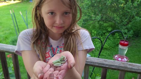 Young-girl-hold-Cope's-Gray-Treefrog-with-fear-in-her-eyes,-Michigan,-USA