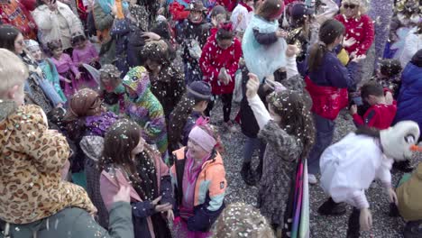 Kinder-In-Karnevalskostümen-Werfen-Konfetti-In-Die-Luft-Während-Der-Gnoccolada-Karnevalsfeier-Im-Freien-In-Brixen,-Südtirol,-Italien