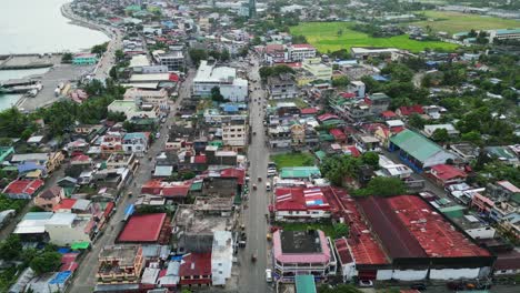 Virac-downtown,-catanduanes-showing-dense-buildings-and-streets-by-the-coast,-aerial-view