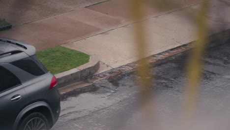 Rainy-Day-in-the-City,-Slow-Motion-of-Raindrops-Falling-on-Street,-Sidewalk-and-Drainage