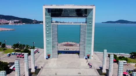 Aerial-forward-ascending-view-of-Xingfu-park-modern-arch-glass-building---Weihai-China
