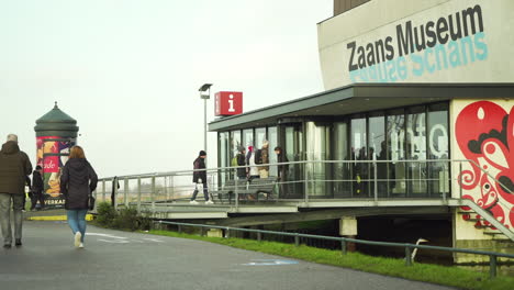 People-walking-outside-of-the-entrance-of-Zaans-Museum,-tourist-attraction