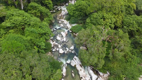Dense-rainforest-and-fast-flowing-water-in-rocky-river-Santa-Marta,-Magdalena,-Colombia,-aerial-view