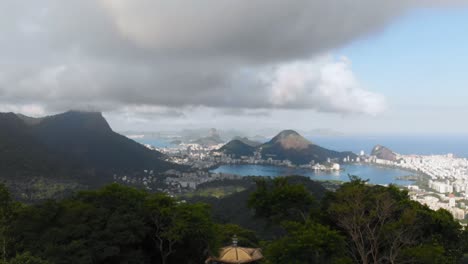 Descend-over-Rio-de-Janeiro's-mountains-with-drone-view-on-a-cloudy-day,-capturing-the-cityscape's-dramatic-beauty