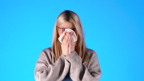 Close-up-ill-woman-sneezing-in-handkerchief,-feeling-unwell,-studio-shot