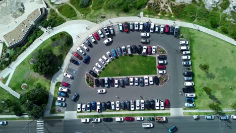 Drone-Aéreo-Sur-Coogee-Autos-Estacionamiento-Conduciendo-En-Estacionamiento-Sobre-Calle-Carretera-Costa-Promontorio-Transporte-Maroubra-Randwick-Sydney-Australia