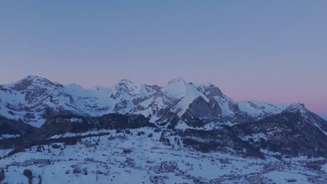 Marvel-at-the-breathtaking-sunrise-over-a-snow-covered-mountain-range-silhouette-from-this-stunning-drone-viewpoint