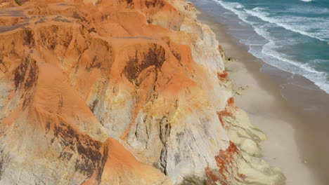 Aerial-view-of-the-sea,-waves,-cliffs-and-small-village,-Morro-Branco,-Ceara,-Brazil