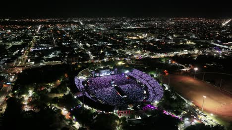 Festival-Musical-Con-Multitud-De-Gente-Celebrando-En-Un-Estadio-Al-Aire-Libre-Por-La-Noche