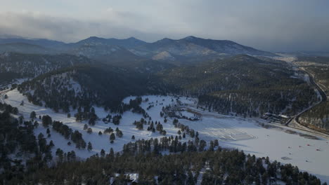 Eislaufen-Schlittschuhlaufen-Eishockeybahn-See-Teich-Eishockey-Winter-Etown-Evergreen-Lake-House-Angelzelte-Denver-Golfplatz-Colorado-Luftaufnahmen-Filmdrohne-Sonnenuntergang-Goldene-Stunde-Winter-Neuschnee-Langsamer-Kreis-Rechts