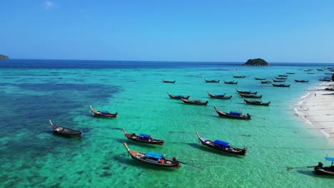 longtail-boats-beach-rocky-cliff-island-turquoise-blue-sea