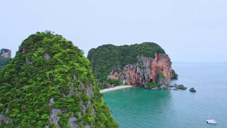 Pedestal-Drone-Shot-Rising-Over-Limestone-Cliffs-to-Reveal-Phra-Nang-Beach-at-Railay,-Thailand